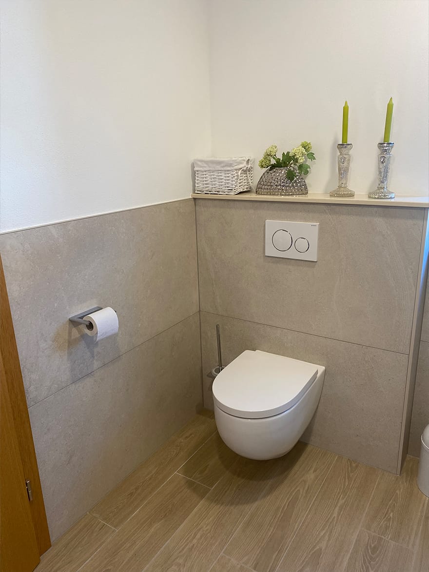Gäste-WC mit großformatigen Fliesen und Holzoptik